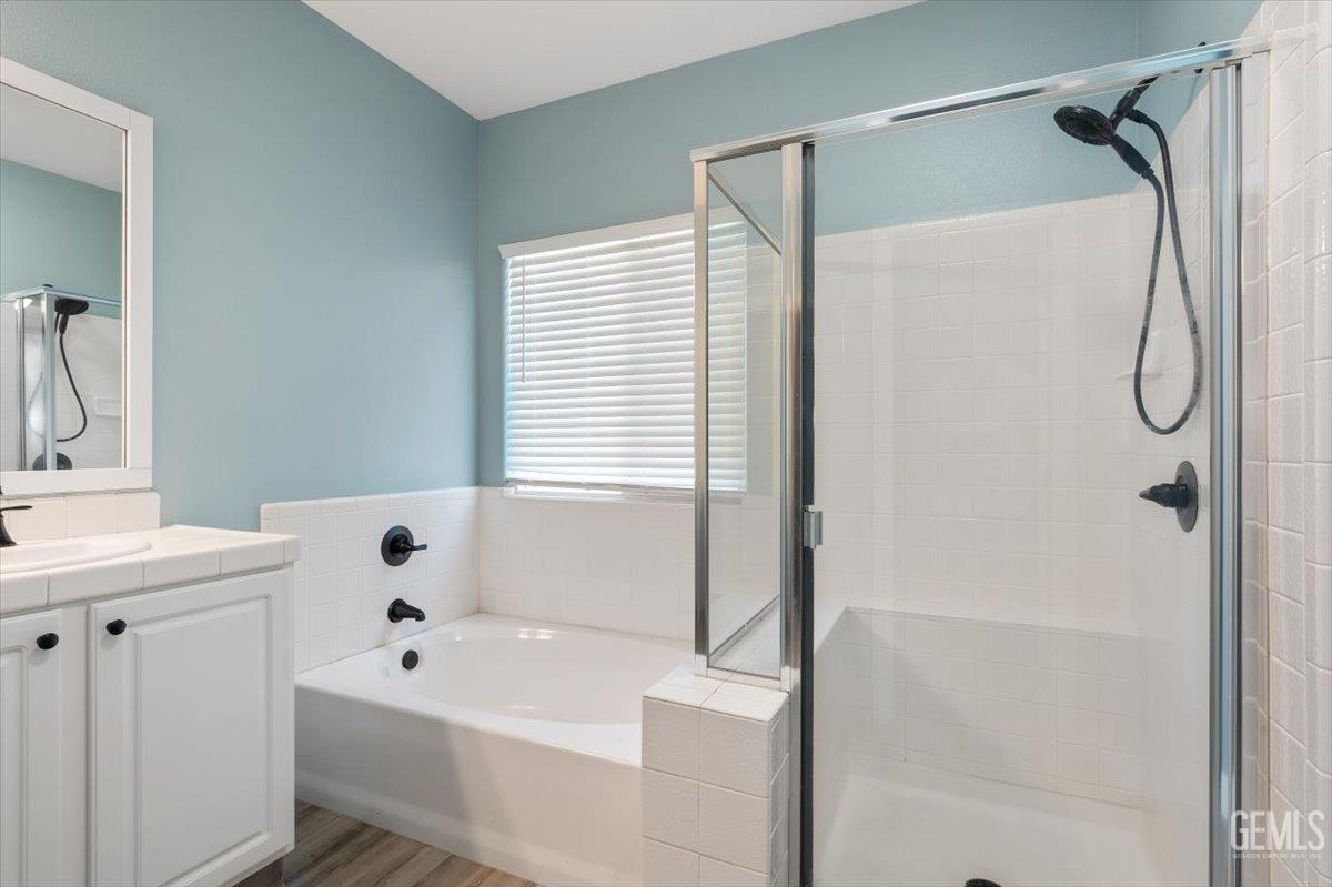 Undisclosed Address Bakersfield, CA 93312 - Photo 15 of 45 a bathroom with a bathtub a sink a window and a shower