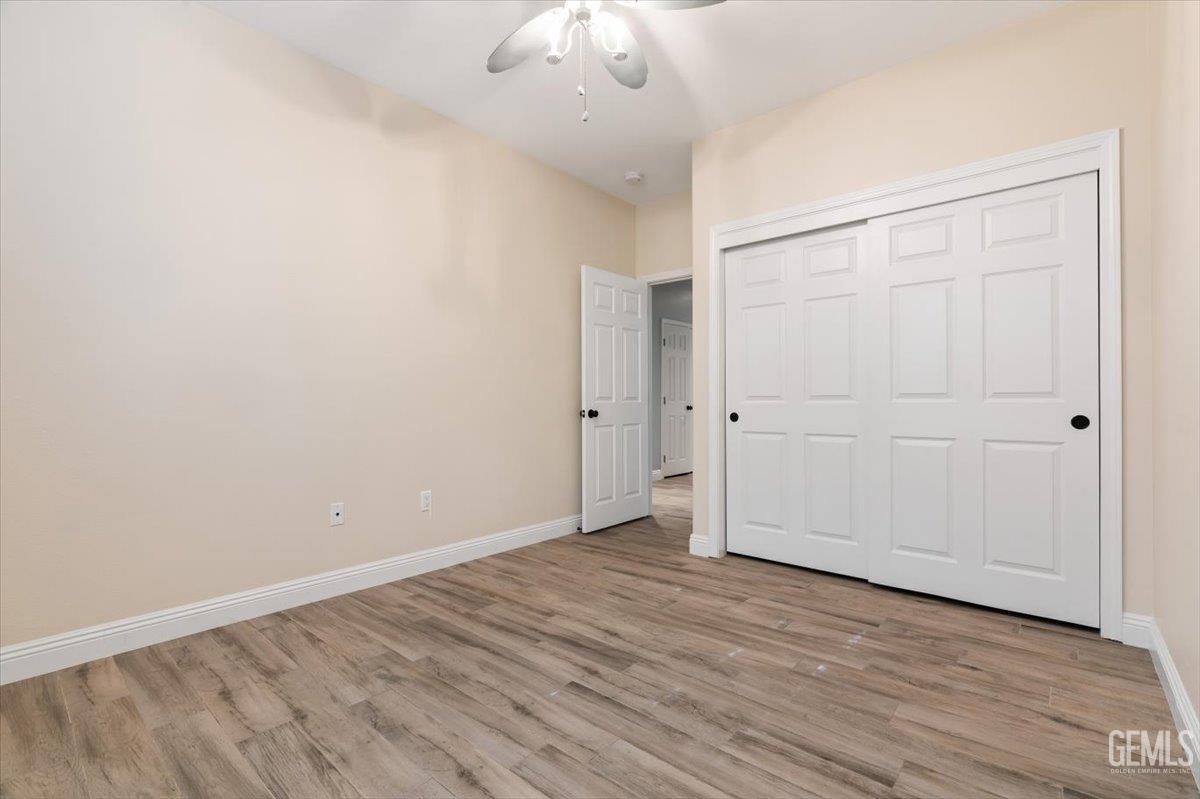 Undisclosed Address Bakersfield, CA 93312 - Photo 19 of 45 an empty room with wooden floor and windows