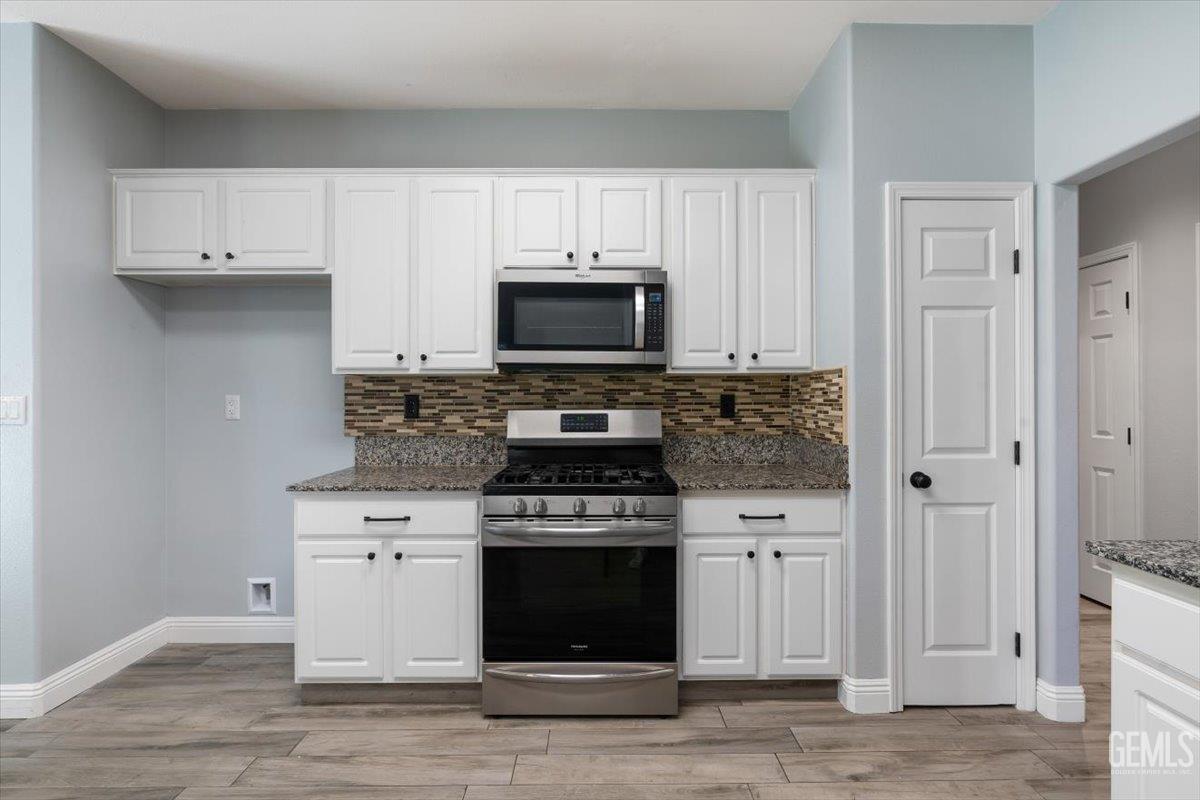 Undisclosed Address Bakersfield, CA 93312 - Photo 37 of 45 a kitchen with cabinets stainless steel appliances and wooden floor