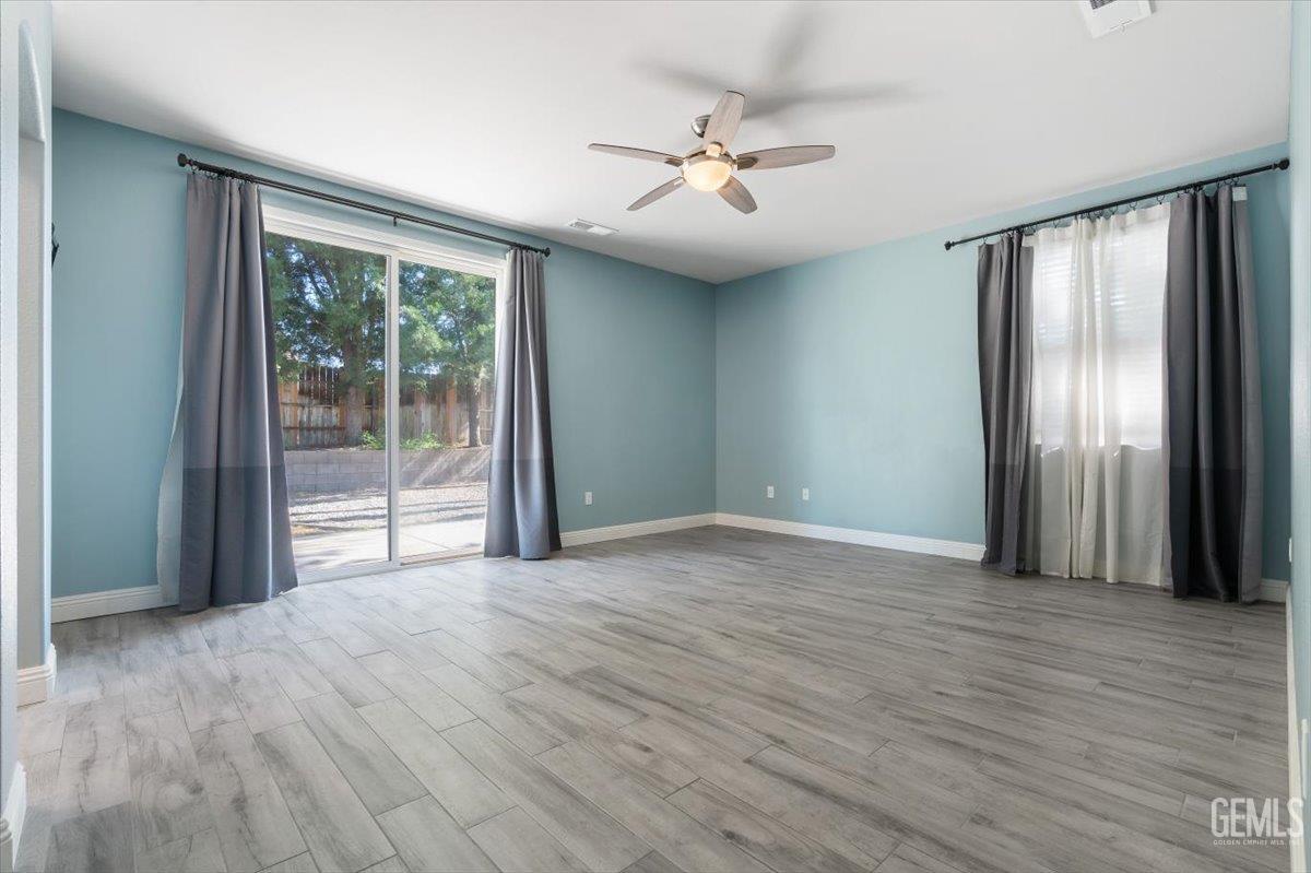 Undisclosed Address Bakersfield, CA 93312 - Photo 10 of 45 a view of an empty room with wooden floor and a window