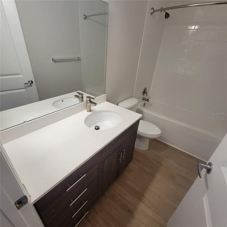 6407 Brook Village Cove, Unit 102 Bradenton, FL 34202 - Photo 13 of 19 a bathroom with a sink a toilet and shower