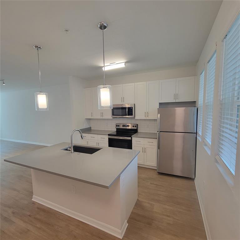 6407 Brook Village Cove, Unit 102 Bradenton, FL 34202 - Photo 5 of 19 a kitchen with a sink stainless steel appliances and refrigerator