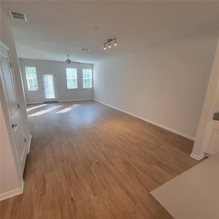 6407 Brook Village Cove, Unit 102 Bradenton, FL 34202 - Photo 6 of 19 wooden floor in an empty room with a window