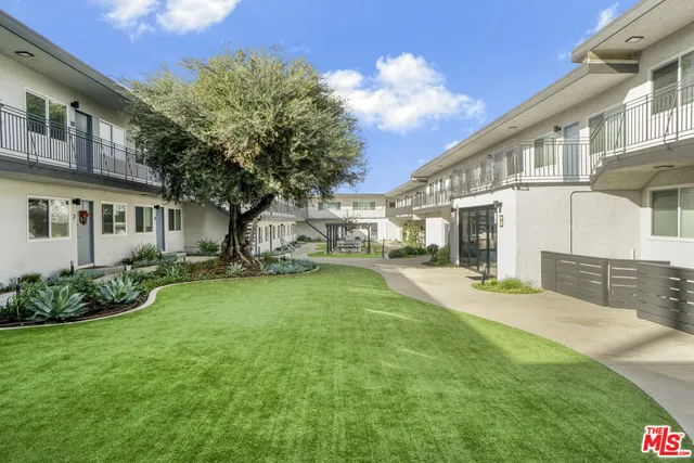 a view of a white house in front of a yard