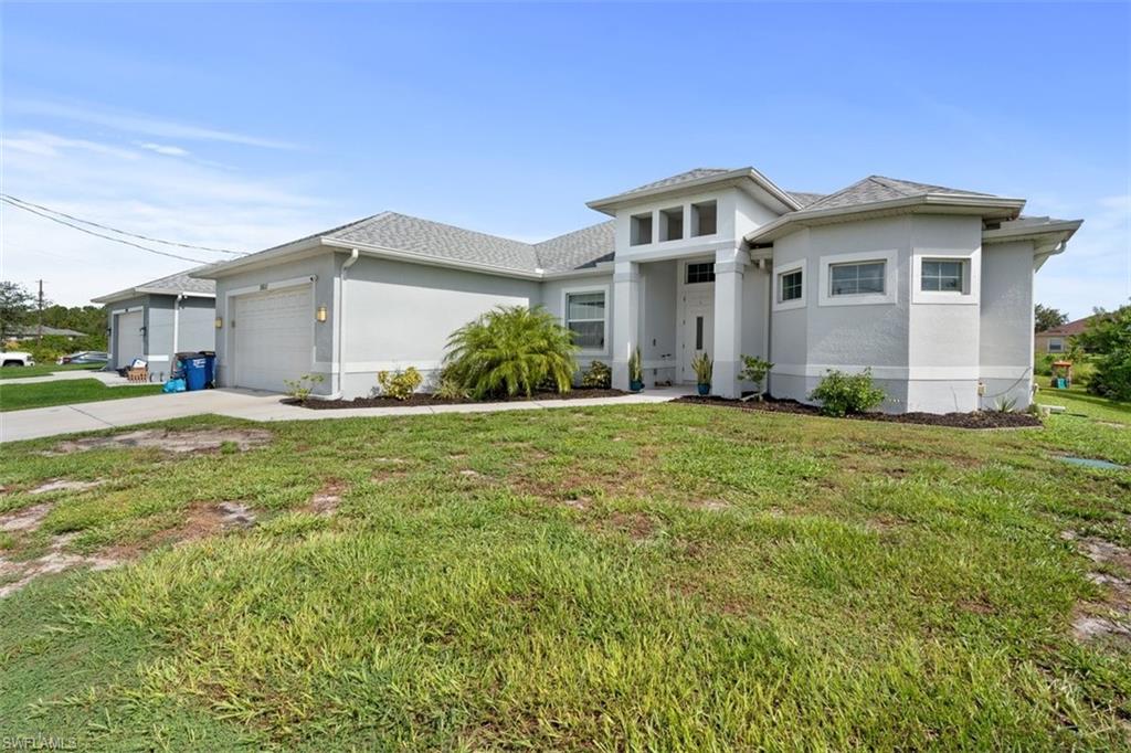 3611 8th Street Southwest Lehigh Acres, FL 33976 - Photo 1 of 21 a front view of a house with a yard