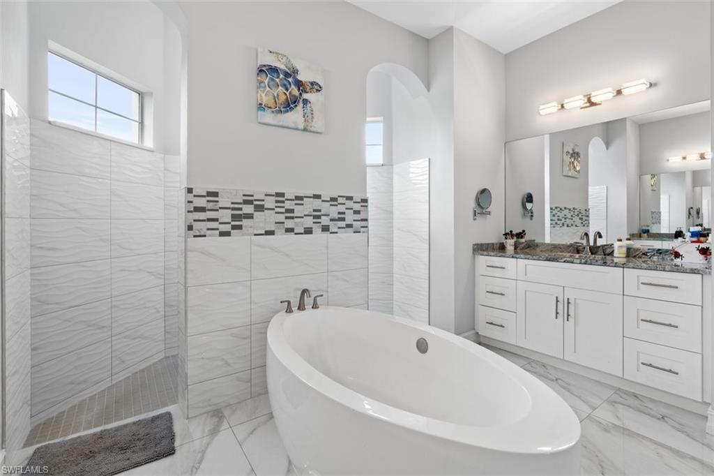 3611 8th Street Southwest Lehigh Acres, FL 33976 - Photo 12 of 21 a bathroom with a bathtub sink and mirror