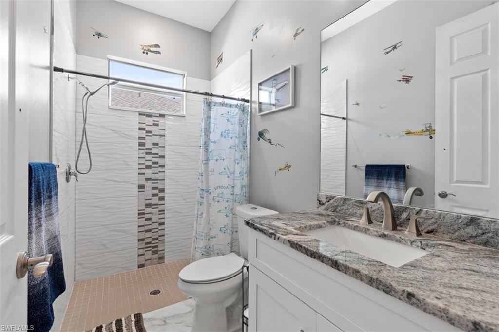 3611 8th Street Southwest Lehigh Acres, FL 33976 - Photo 15 of 21 a bathroom with a granite countertop sink toilet and shower