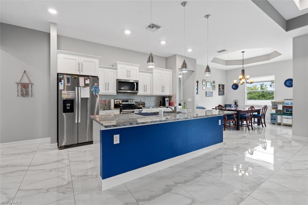 3611 8th Street Southwest Lehigh Acres, FL 33976 - Photo 6 of 21 a large kitchen with stainless steel appliances lots of counter top space cabinets and a refrigerator
