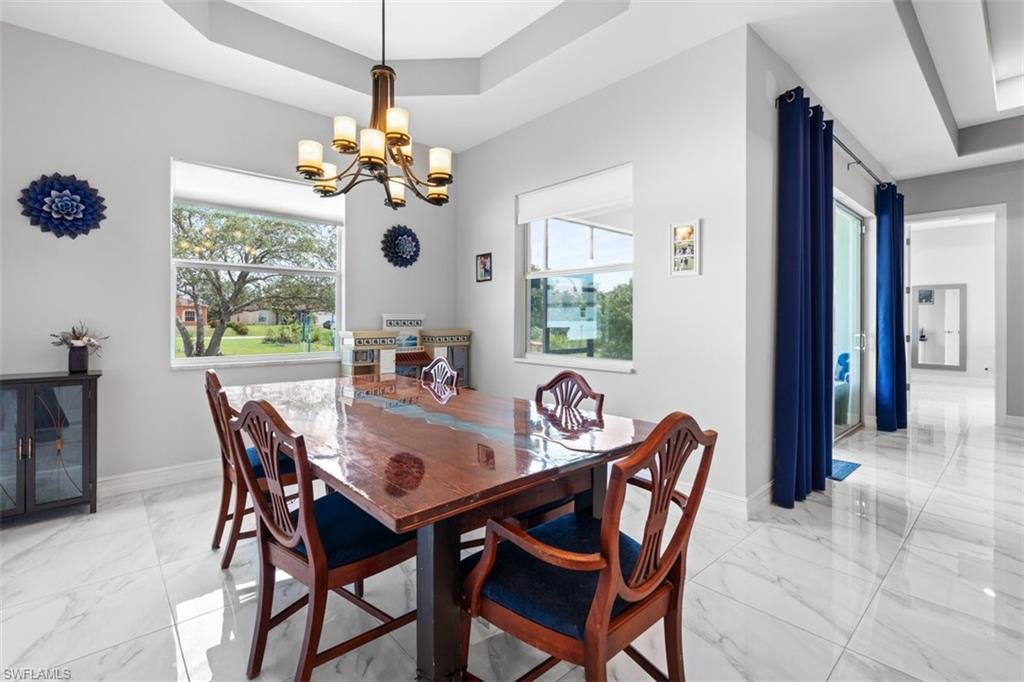 3611 8th Street Southwest Lehigh Acres, FL 33976 - Photo 7 of 21 a dining room with furniture a chandelier and a rug