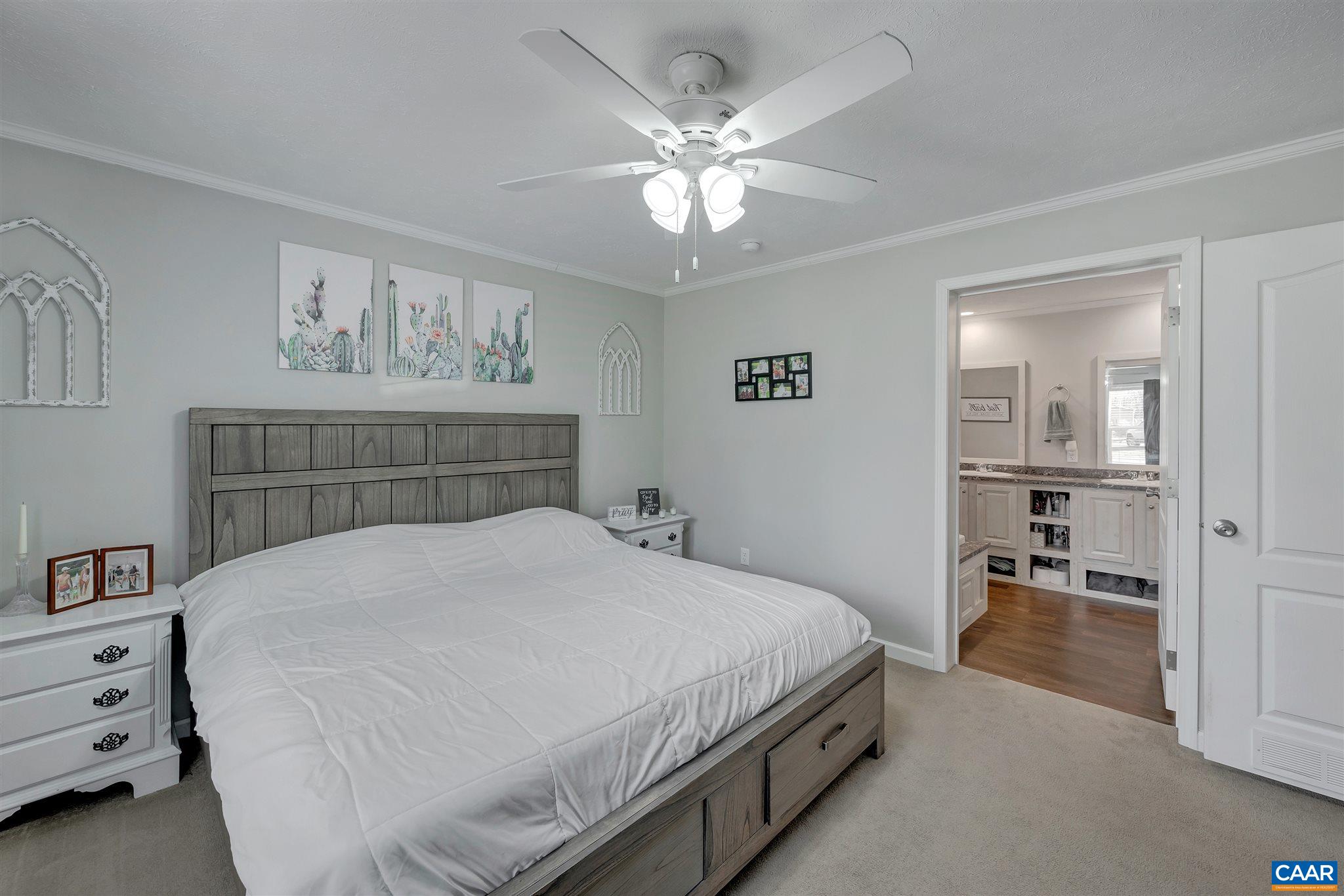 4491 Amicus Road Ruckersville, VA 22968 - Photo 15 of 37 a bedroom with a large bed and a chandelier