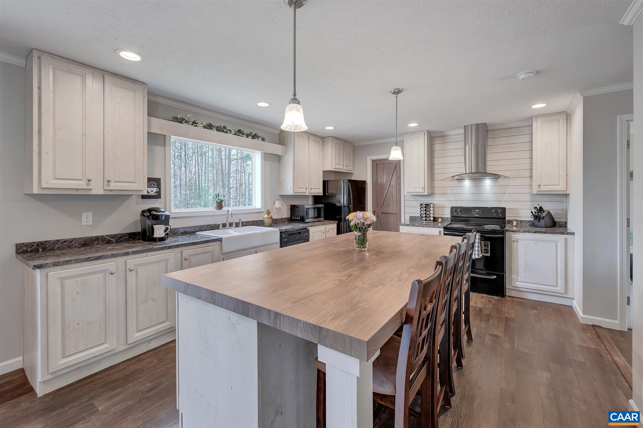 4491 Amicus Road Ruckersville, VA 22968 - Photo 5 of 37 a kitchen with kitchen island granite countertop a sink a center island and cabinets