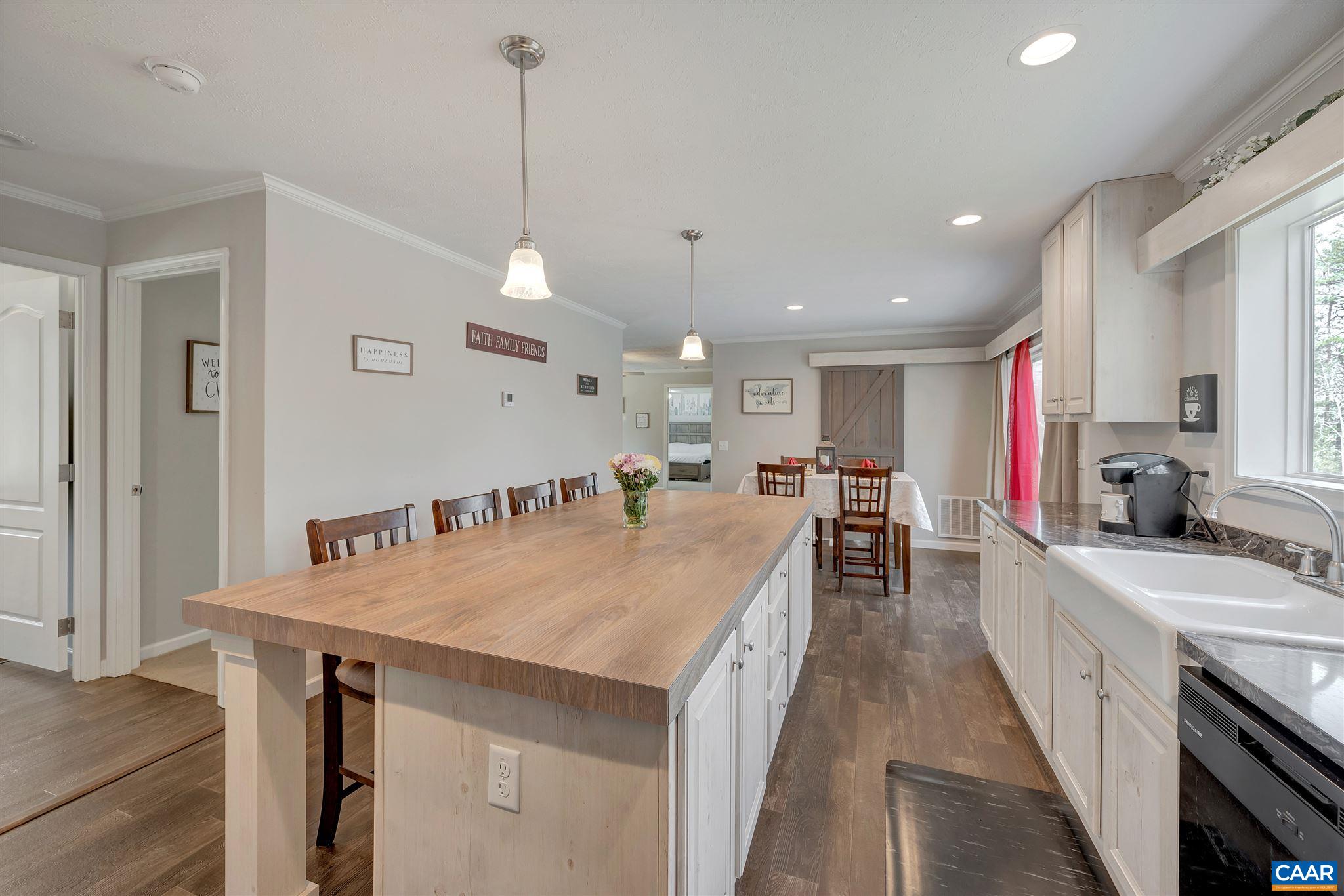 4491 Amicus Road Ruckersville, VA 22968 - Photo 9 of 37 a large kitchen with sink a refrigerator and chairs
