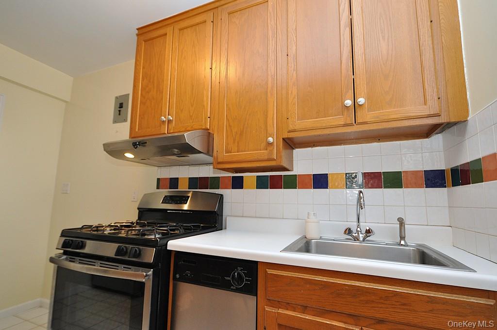 142 Garth Road, Unit 5S Scarsdale, NY 10583 - Photo 11 of 40 a kitchen with a sink and a stove top oven