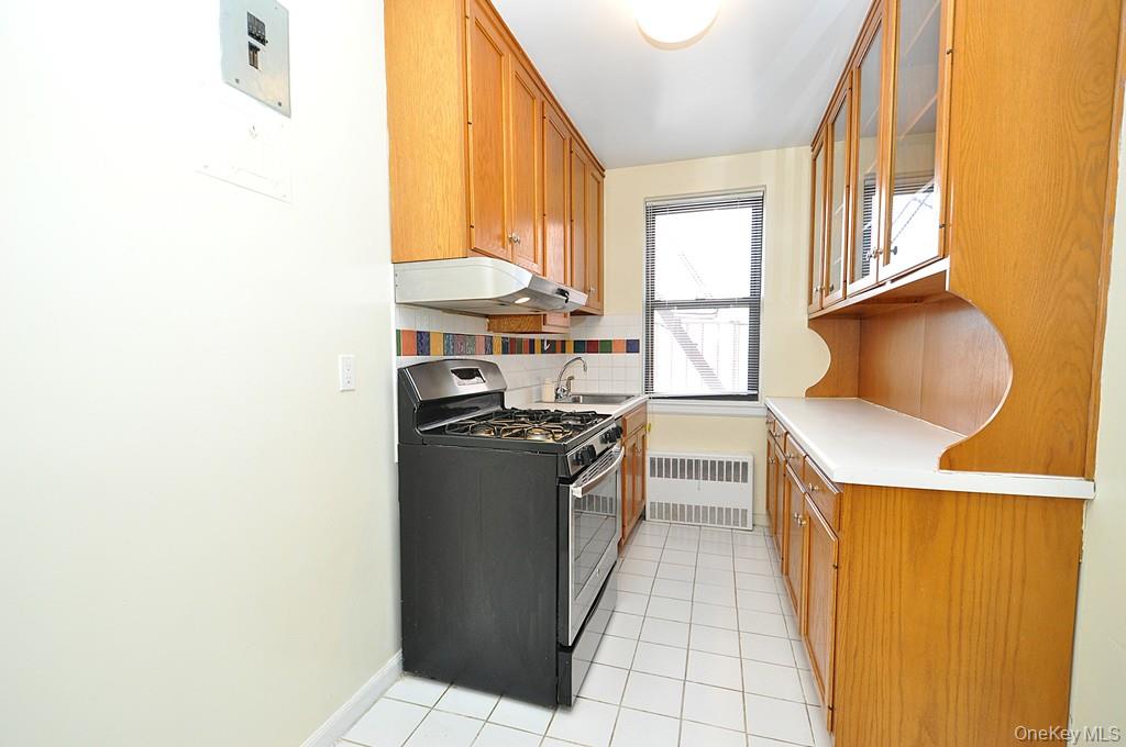 142 Garth Road, Unit 5S Scarsdale, NY 10583 - Photo 14 of 40 a kitchen with stainless steel appliances granite countertop a stove a sink and a microwave