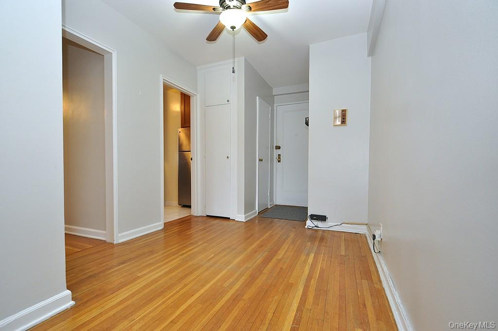 142 Garth Road, Unit 5S Scarsdale, NY 10583 - Photo 17 of 40 a view of a room with wooden floor and ceiling fan