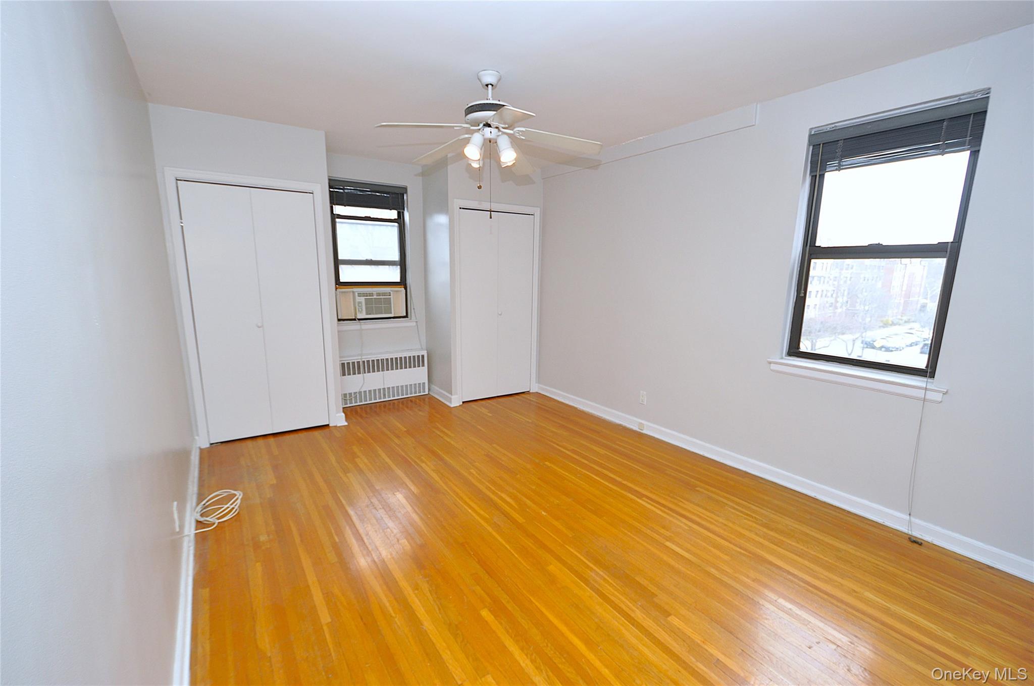 142 Garth Road, Unit 5S Scarsdale, NY 10583 - Photo 21 of 40 a view of empty room with wooden floor and fan