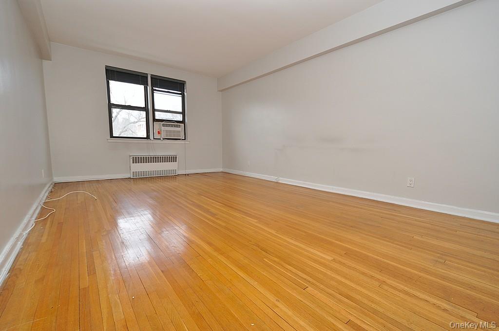 142 Garth Road, Unit 5S Scarsdale, NY 10583 - Photo 4 of 40 a view of empty room with wooden floor and fan