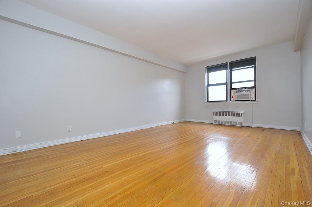 142 Garth Road, Unit 5S Scarsdale, NY 10583 - Photo 5 of 40 a view of empty room with wooden floor and fan