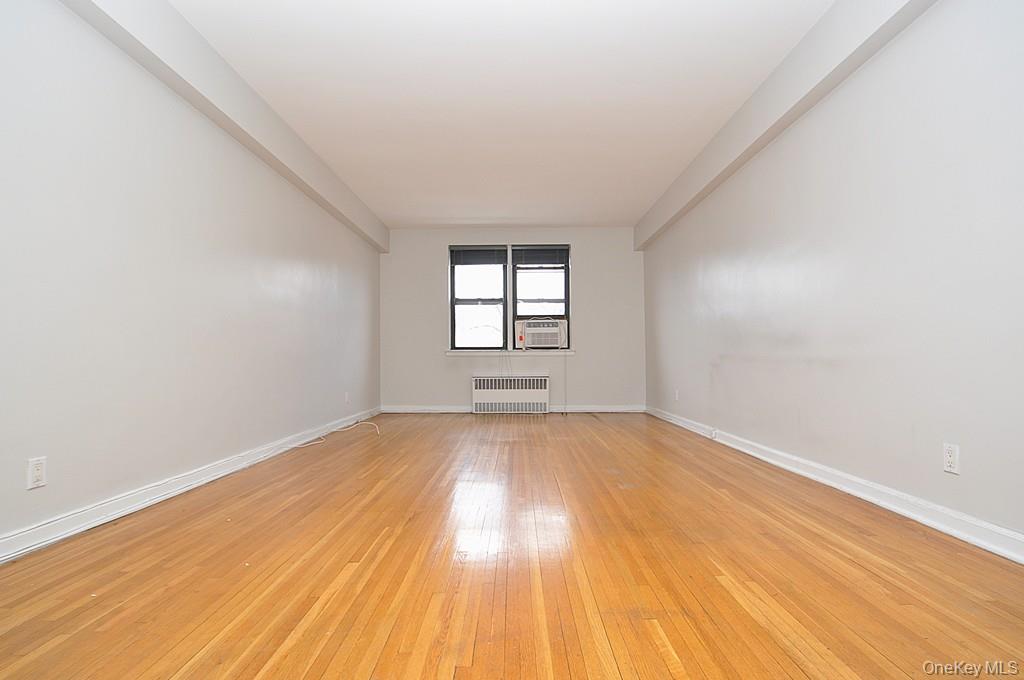 142 Garth Road, Unit 5S Scarsdale, NY 10583 - Photo 8 of 40 an empty room with wooden floor and windows