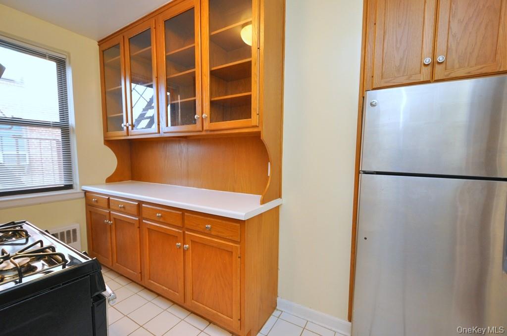 142 Garth Road, Unit 5S Scarsdale, NY 10583 - Photo 9 of 40 a kitchen with stainless steel appliances granite countertop a refrigerator and a stove
