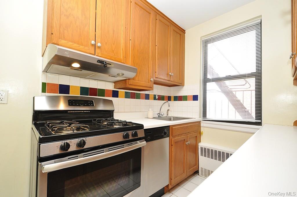 142 Garth Road, Unit 5S Scarsdale, NY 10583 - Photo 10 of 40 a kitchen with stainless steel appliances a stove a sink and a cabinets