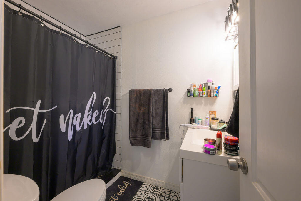 1044 4th Street Okeechobee, FL 34974 - Photo 18 of 39 a bathroom with a sink and a shower curtain