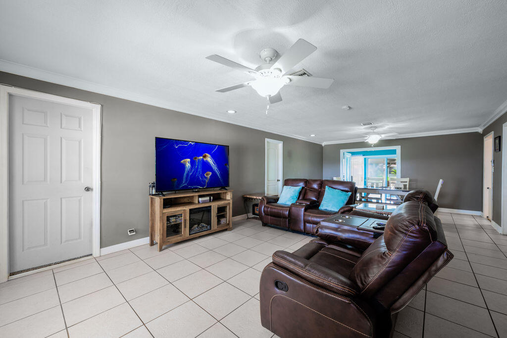 1044 4th Street Okeechobee, FL 34974 - Photo 10 of 39 a living room with furniture and a flat screen tv