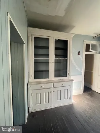 a view of empty room with wooden floor and fireplace
