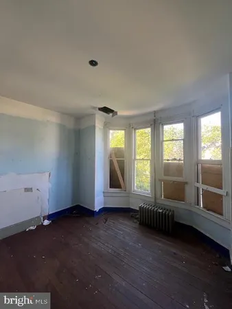 a view of a livingroom with wooden floor and a ceiling fan