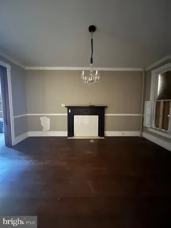 a view of empty room with wooden floor and windows