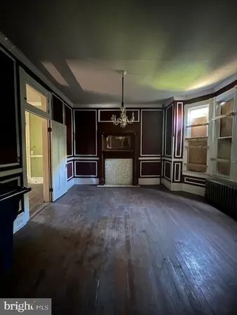 a view of empty room with wooden floor and windows