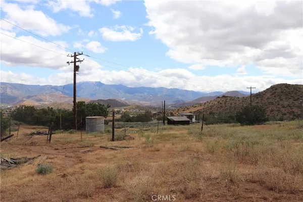 a view of a dry yard with mountains in the background