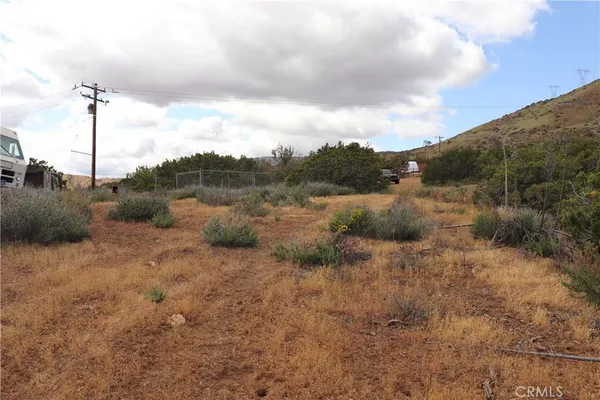 a view of a dry yard with mountains in the background