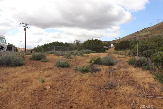 a view of a dry yard with mountains in the background