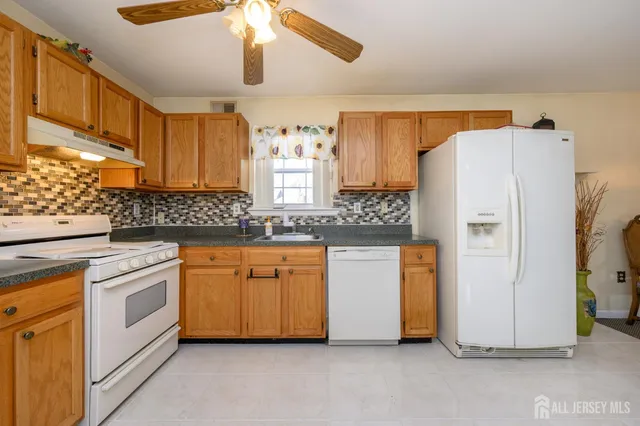 a kitchen with white cabinets and white appliances