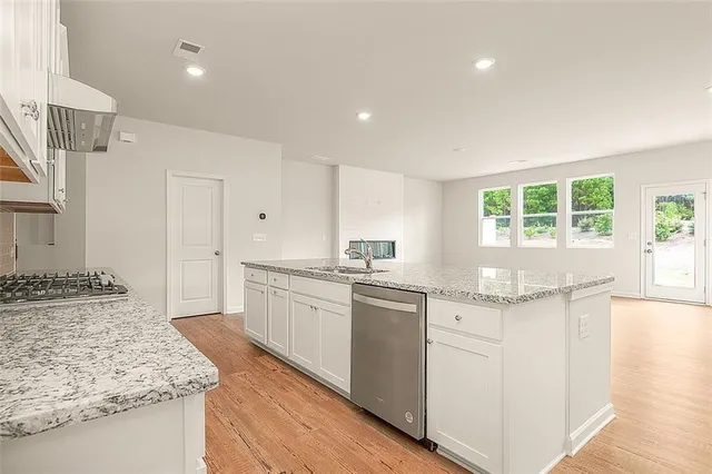 a kitchen with granite countertop a sink stove and refrigerator