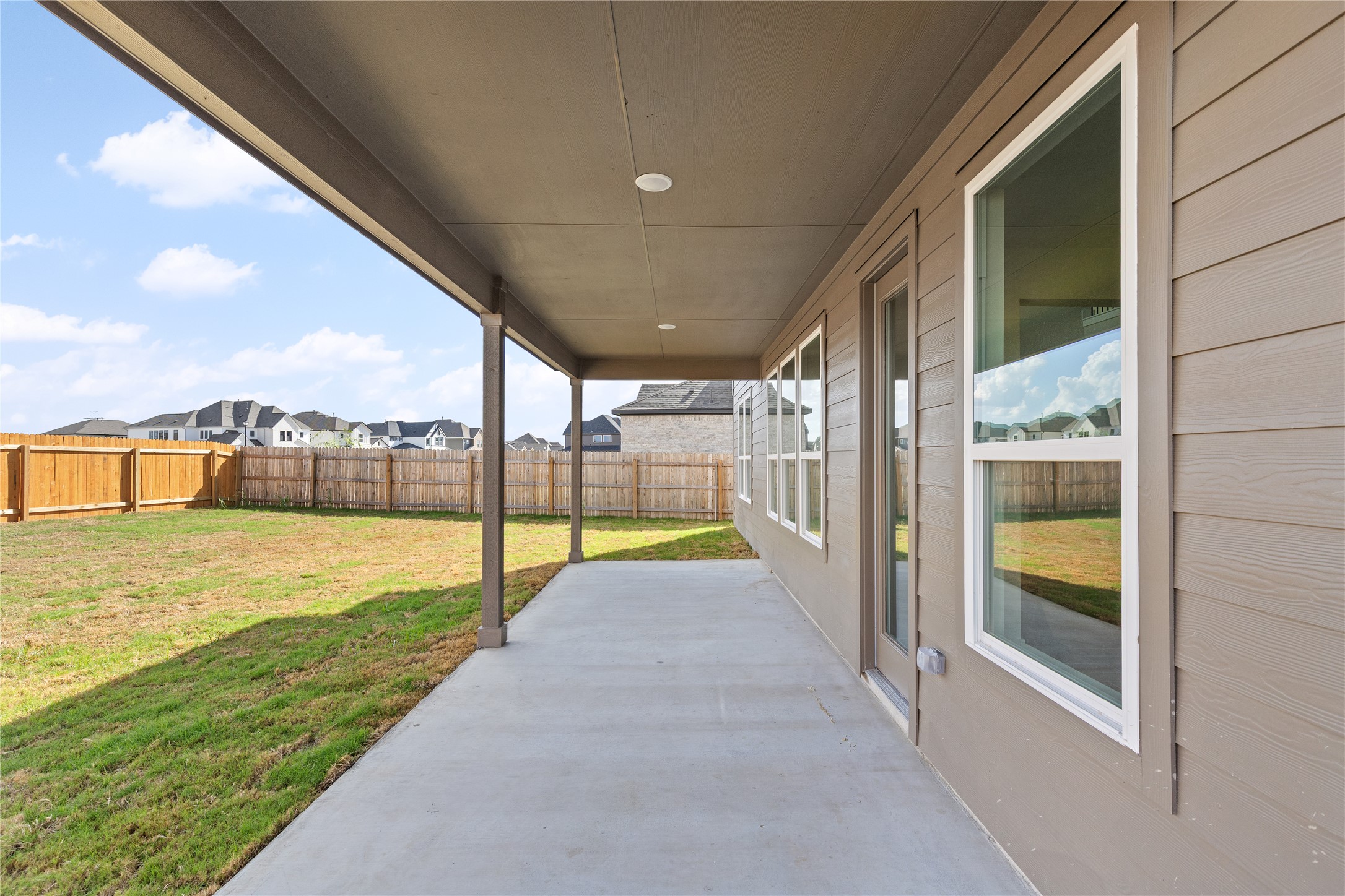 19705 Domino Champ Road Pflugerville, TX 78660 - Photo 37 of 38 A spacious covered concrete patio overlooks a fully fenced grassy backyard.