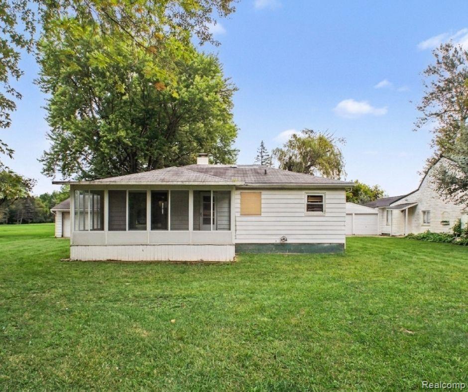 5082 North Center Road Flint, MI 48506 - Photo 8 of 21 Screened-in porch, white siding exterior, expansive green lawn, mature trees, detached garage