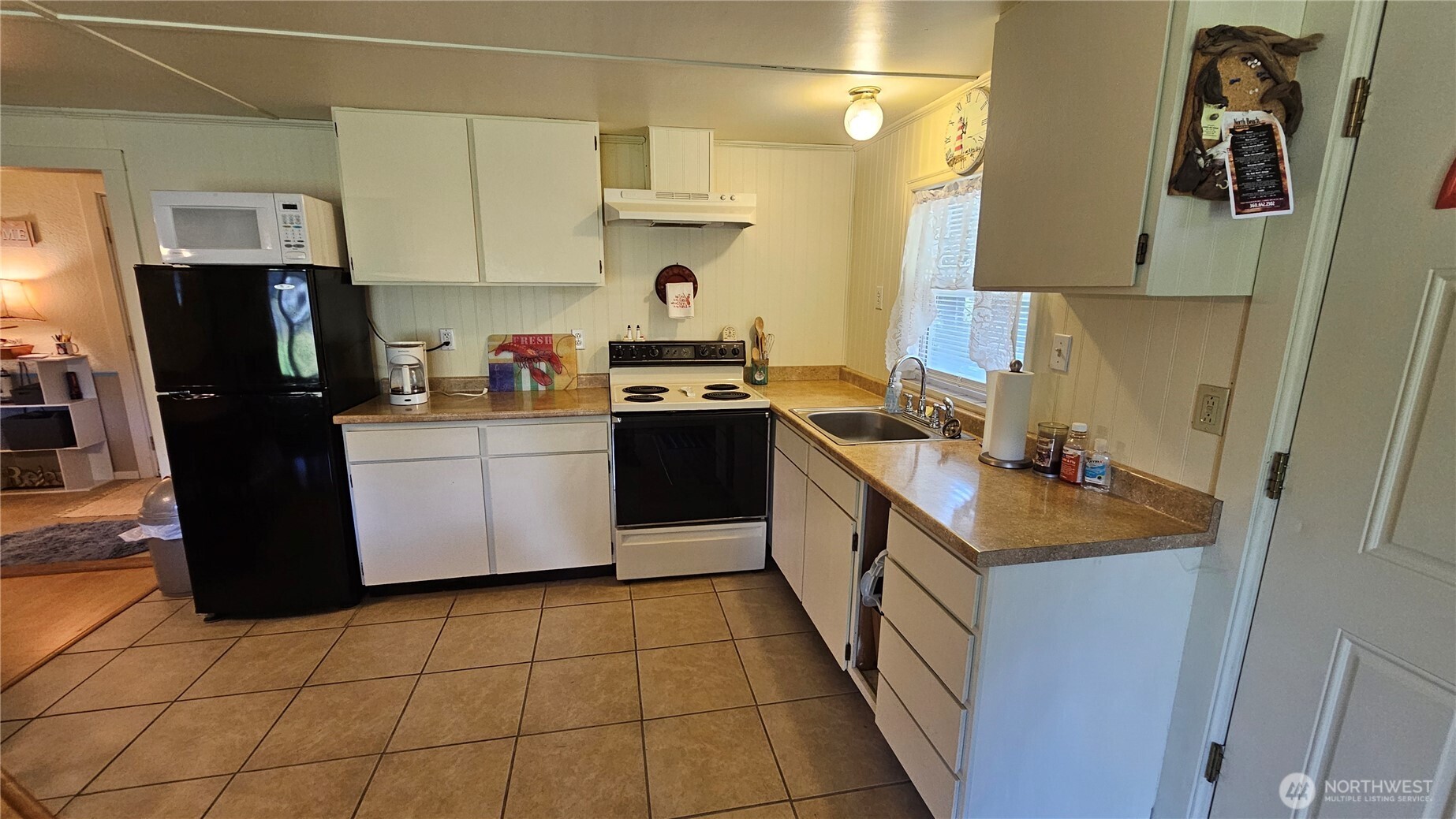 24402 P Street Ocean Park, WA 98640 - Photo 31 of 40 a kitchen with a sink a stove top oven a refrigerator and cabinets
