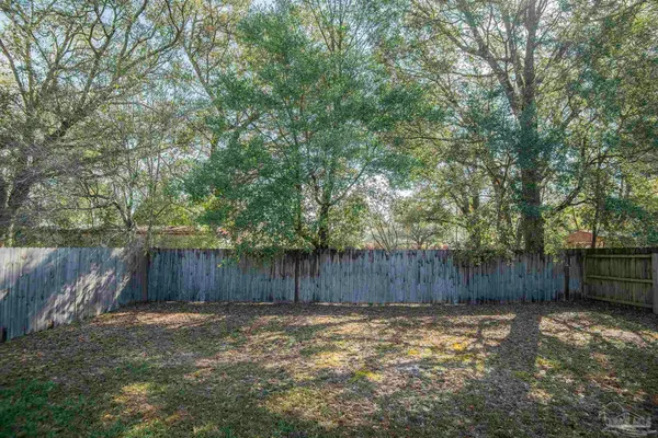 a view of a backyard with wooden fence