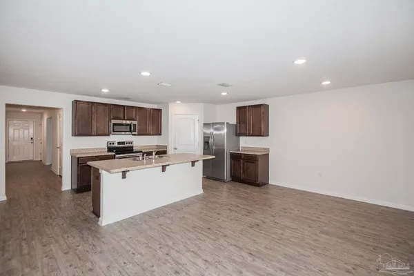 a kitchen with kitchen island a sink appliances and cabinets