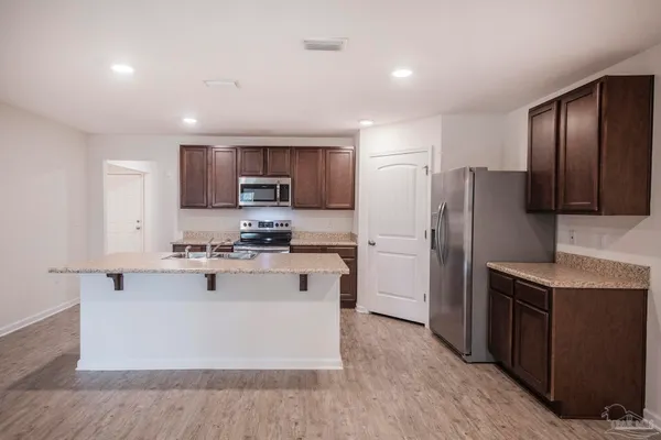 a kitchen with stainless steel appliances granite countertop a sink stove and microwave