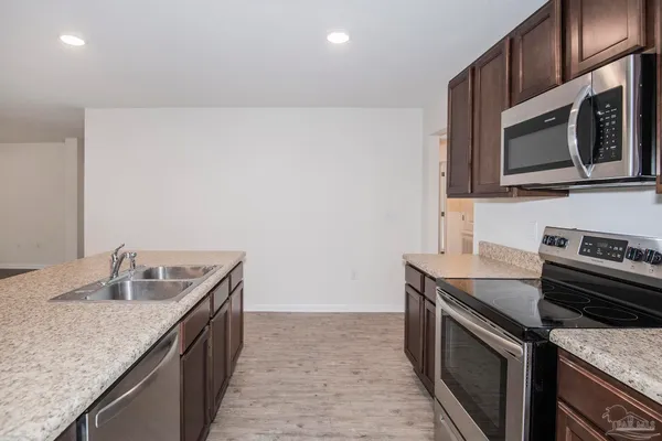 a kitchen with stainless steel appliances granite countertop a sink and a refrigerator
