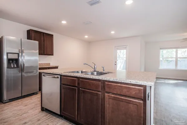 a large white kitchen with a stove a sink and a microwave