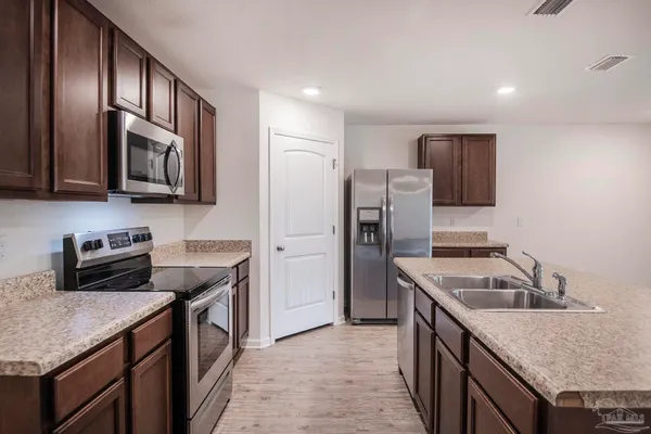 a view of a backyard with plants and wooden fence