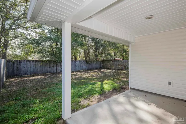 a front view of house with yard and trees in the background