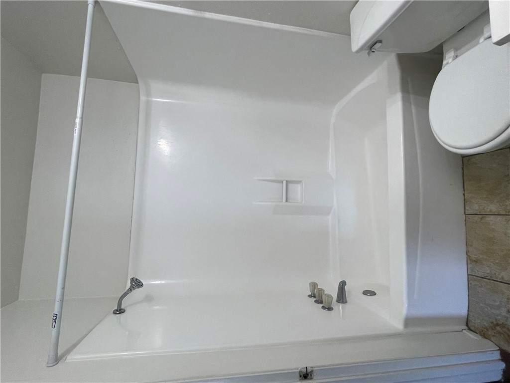 807 East 31st Street, Unit 9 Bryan, TX 77803 - Photo 7 of 7 a bathroom with a white toilet and a bath tub