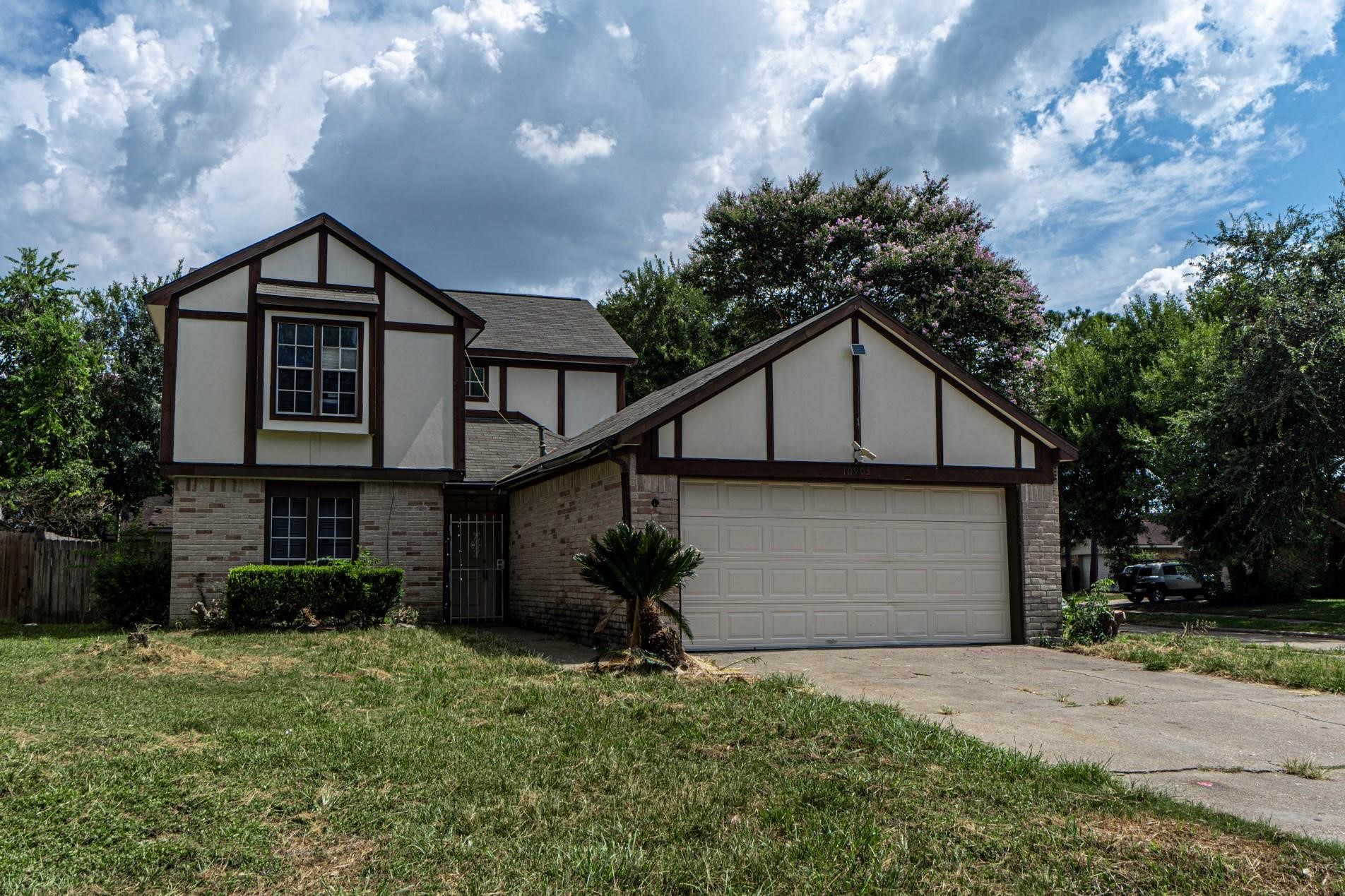 a front view of house with yard and trees in the background