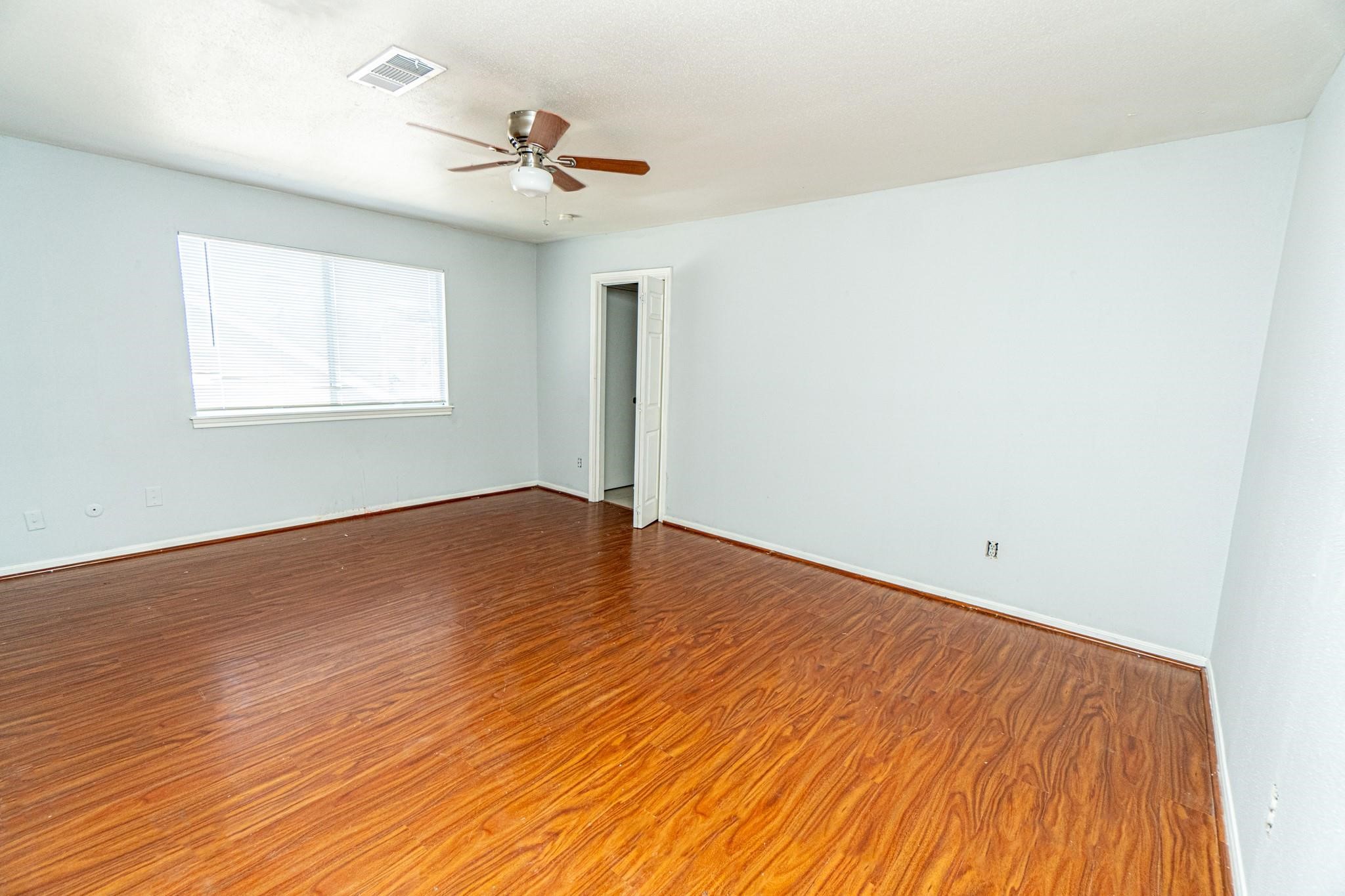 10903 Nobility Drive Houston, TX 77099 - Photo 11 of 12 a view of empty room with wooden floor and fan