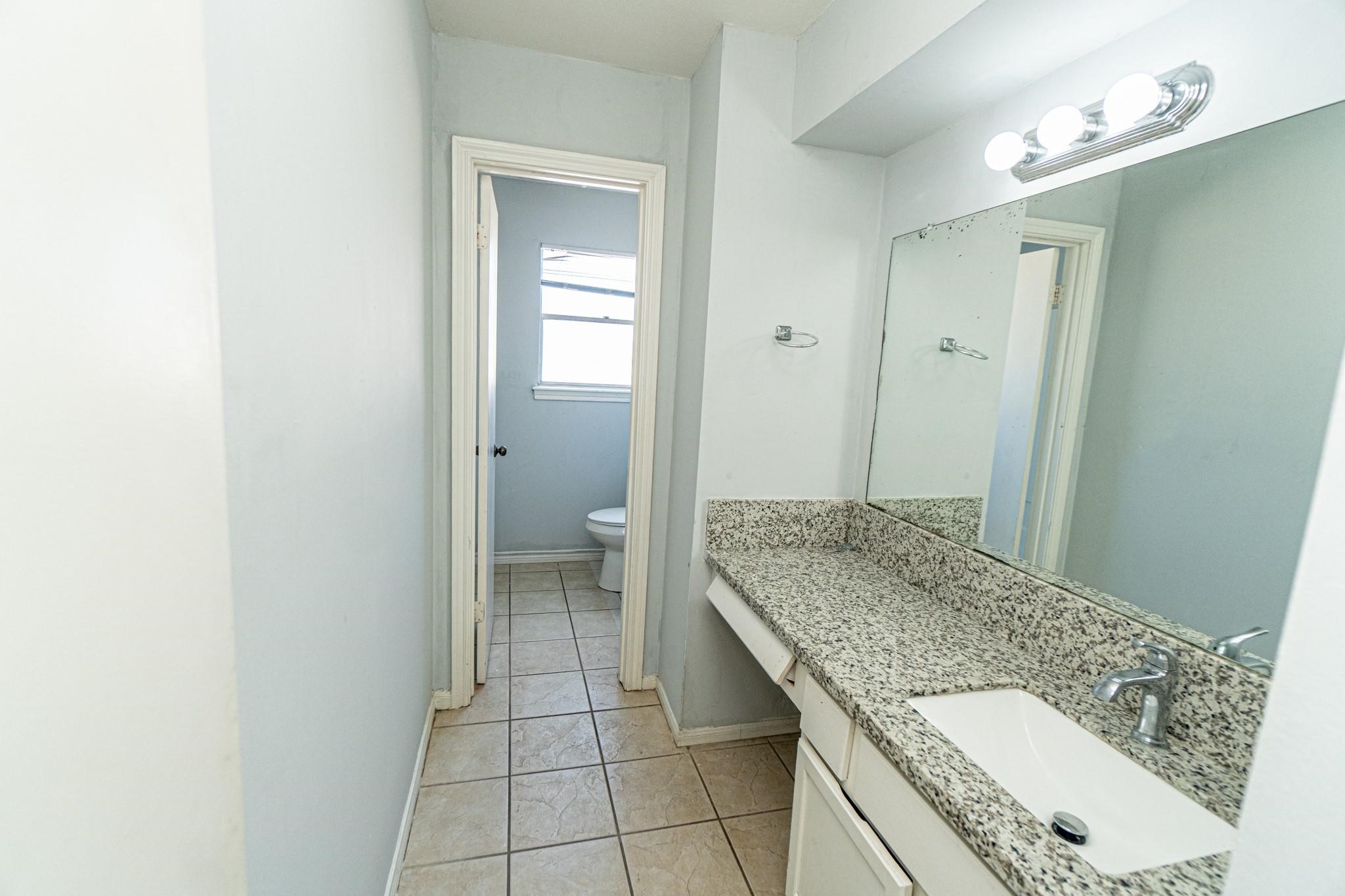 10903 Nobility Drive Houston, TX 77099 - Photo 12 of 12 a bathroom with a granite countertop sink and a mirror